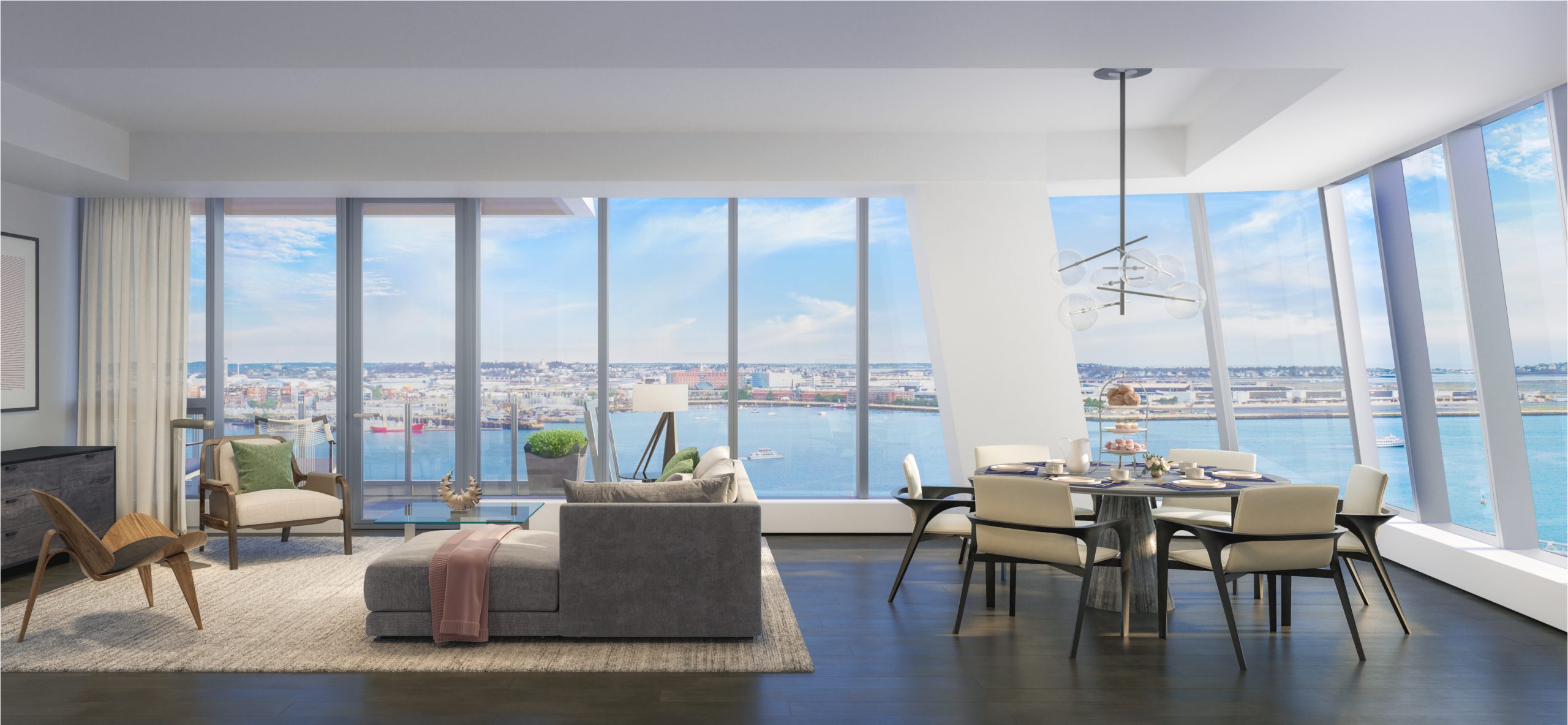 View of a living area at St. Regis Boston, The Residences. Boston Harbor is visible through the windows.