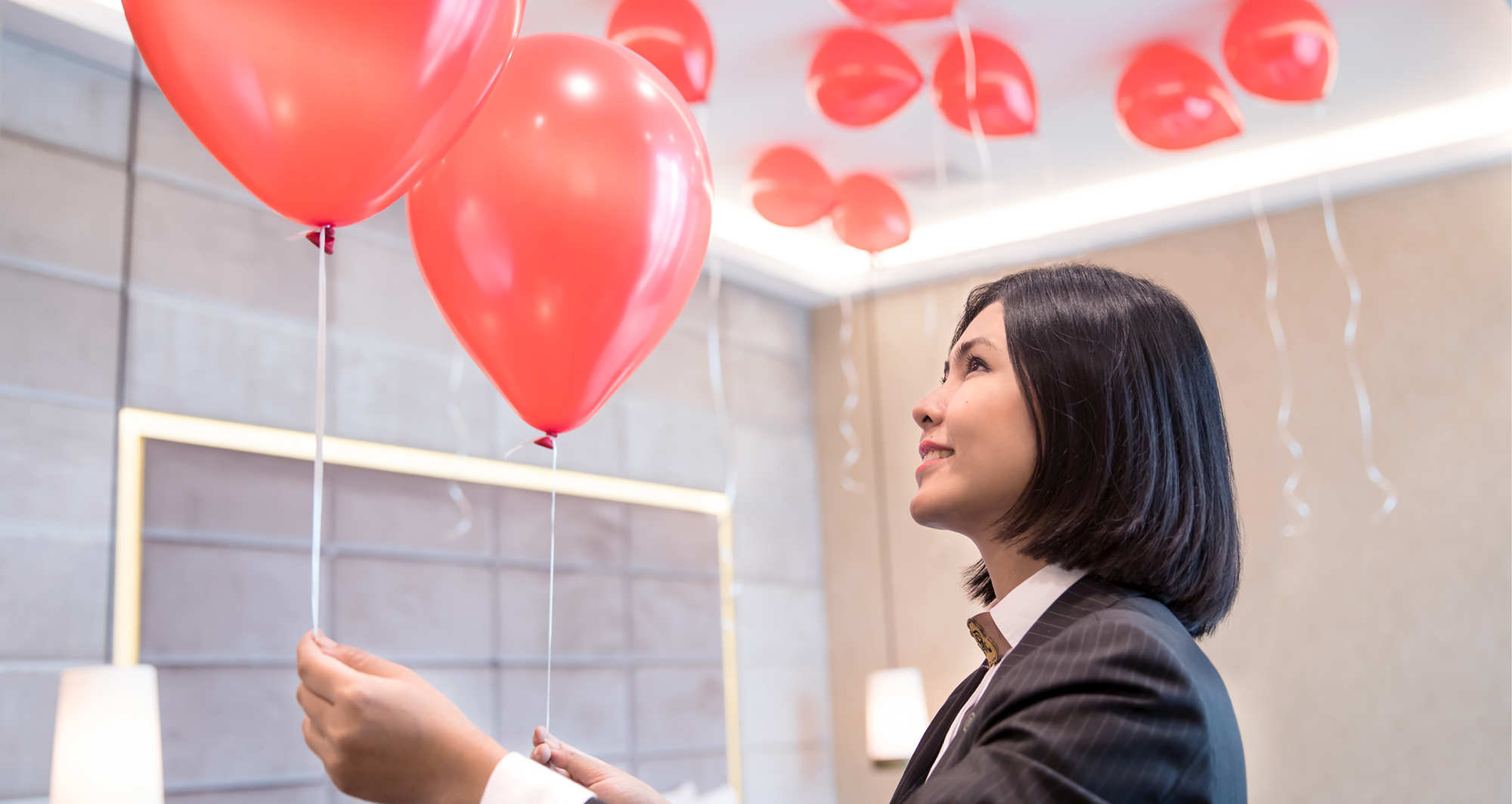 A member of staff arranges balloons at St. Regis Boston, The Residences.