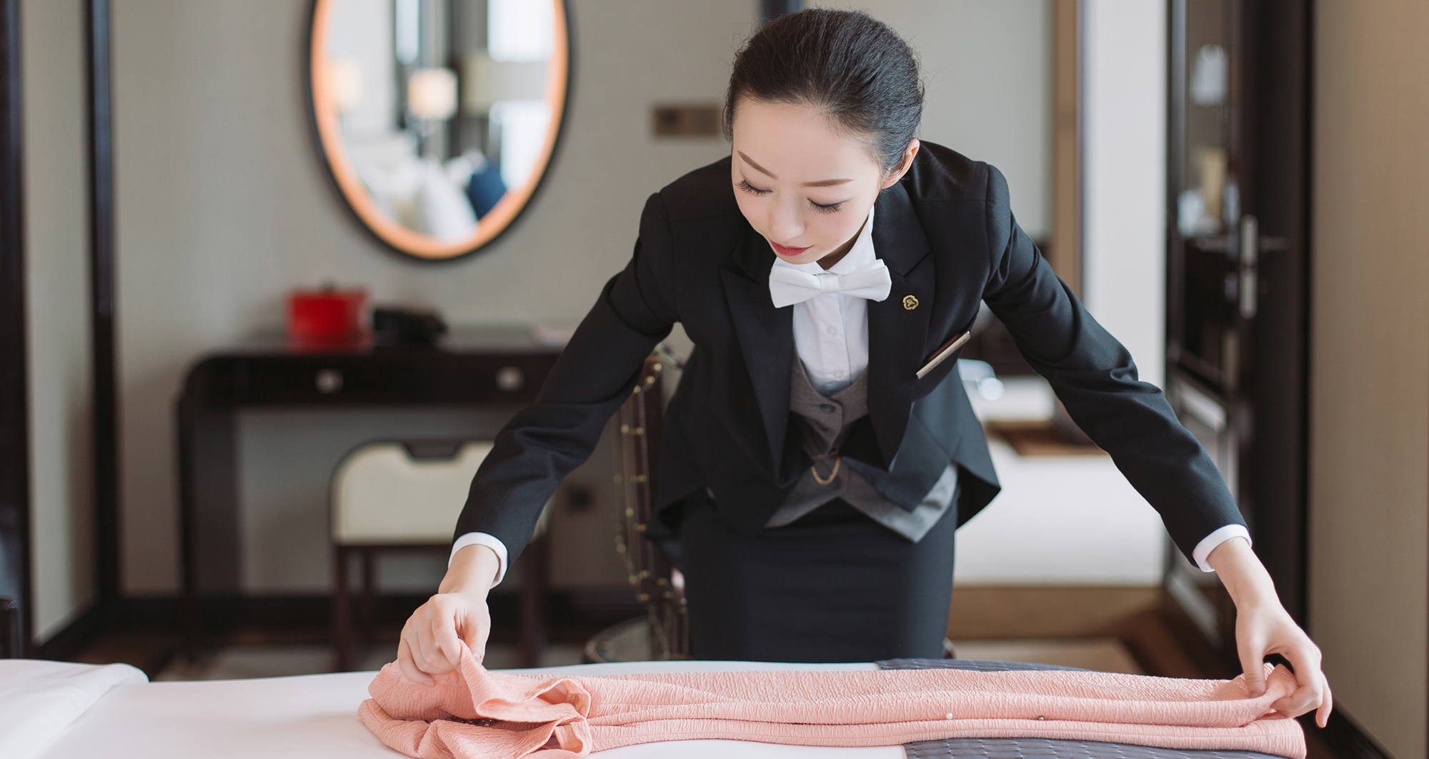 A butler folding clothing at St. Regis Boston, The Residences.